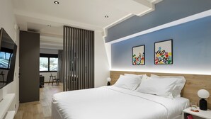 Una camera da letto moderna con un letto grande, una TV e opere d'arte alle pareti.
