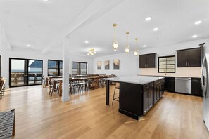 A spacious kitchen with a central island, modern pendant lights, and a view to the outside. - House of FUN! Games, Lakeview, Bunkroom! (Branson)