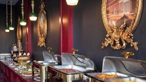 A buffet setup with multiple food stations, elegant wall decor, and a long dining table. - Sam hotel Tbilisi (Tbilisi)