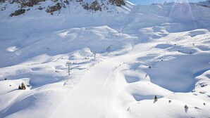 Ett snötäckt berglandskap med skidliftar och en klar himmel.