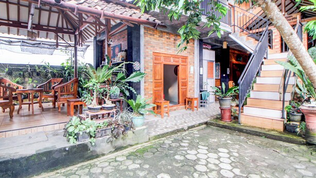 A traditional wooden house with a tiled roof, a wooden staircase, and potted plants. - Hotel O Maryam Homestay Syariah 2 (Patuk)