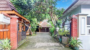 A traditional house with a tiled entrance, a brick wall, and a wooden staircase leading to a door. - Hotel O Maryam Homestay Syariah 2 (Patuk)