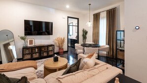 Una sala de estar moderna con un sofá, una mesa de centro y un televisor montado en la pared.