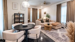 Una sala de estar moderna con una mesa redonda de comedor, dos sofás, una mesa de centro y una estantería.