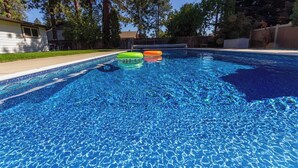 A clear blue swimming pool with inflatable rings. - Charming 3 Bed, 2 and a half Bath Family Oasis - Pool, BBQ, Fire Pit (Spokane Valley)