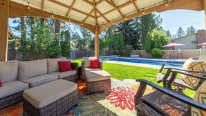A covered patio with outdoor furniture, a pool, and a view of the backyard. - Charming 3 Bed, 2 and a half Bath Family Oasis - Pool, BBQ, Fire Pit (Spokane Valley)