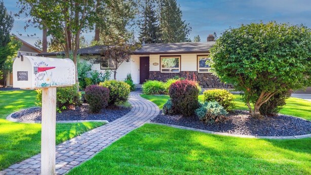 A residential house with a mailbox, a paved driveway, and well-maintained landscaping including various shrubs and a tree. - Charming 3 Bed, 2 and a half Bath Family Oasis - Pool, BBQ, Fire Pit (Spokane Valley)