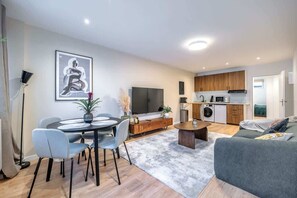 A modern apartment with a dining area, a living room, and a kitchen.