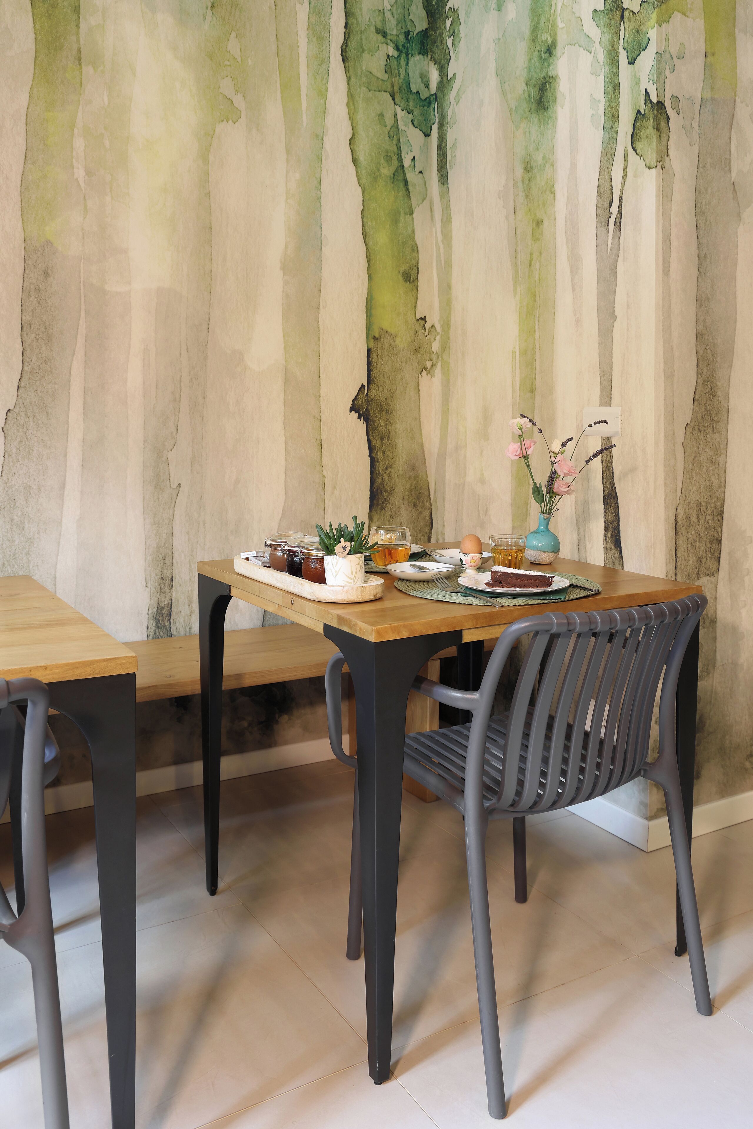 Een eetgedeelte met een houten tafel, stoelen en een wand met verticale lijnen.