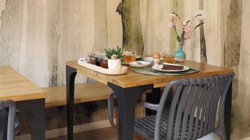 Een eetgedeelte met een houten tafel, stoelen en een wand met verticale lijnen.