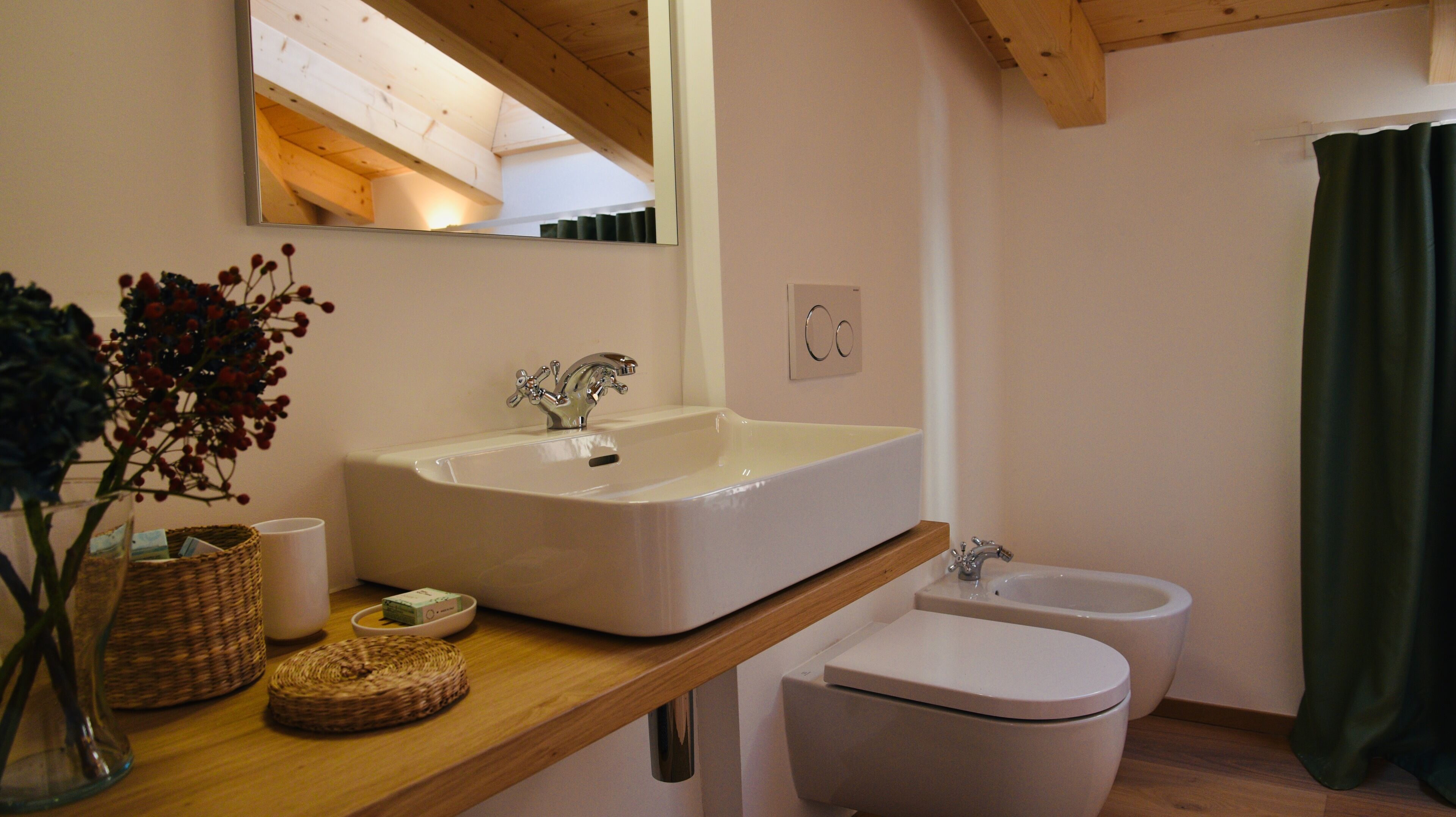 Un bagno con un lavandino ampio, un WC e uno specchio.