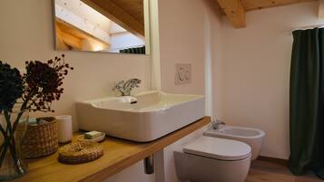 Un bagno con un lavandino ampio, un WC e uno specchio.