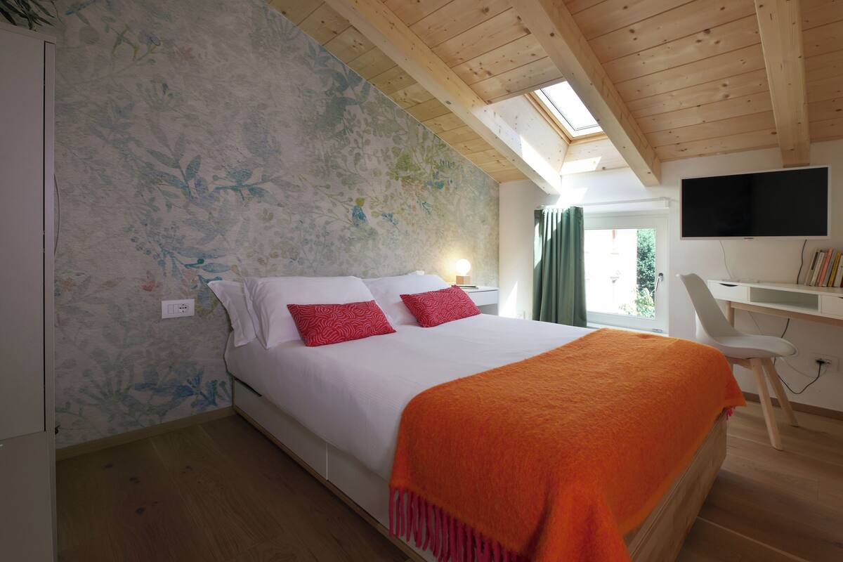 Un dormitorio con cama, escritorio y televisión.