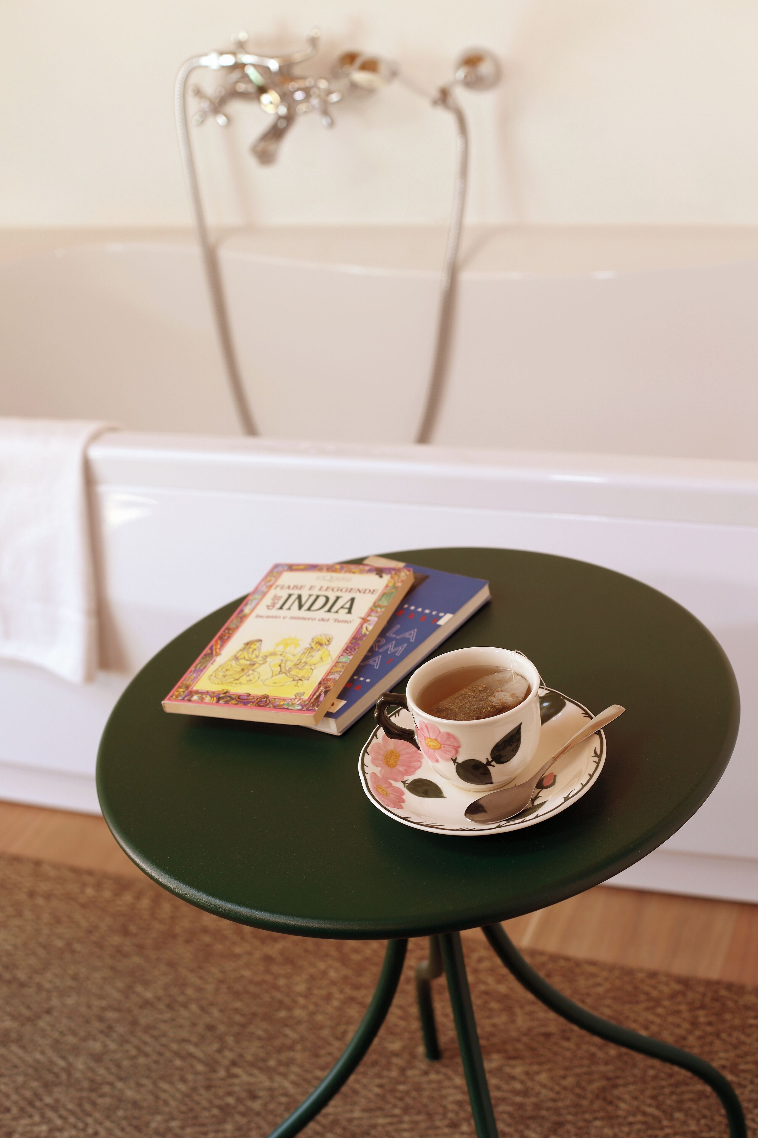 Une petite table sur laquelle se trouve un livre intitulé « Inde » et une tasse de thé.