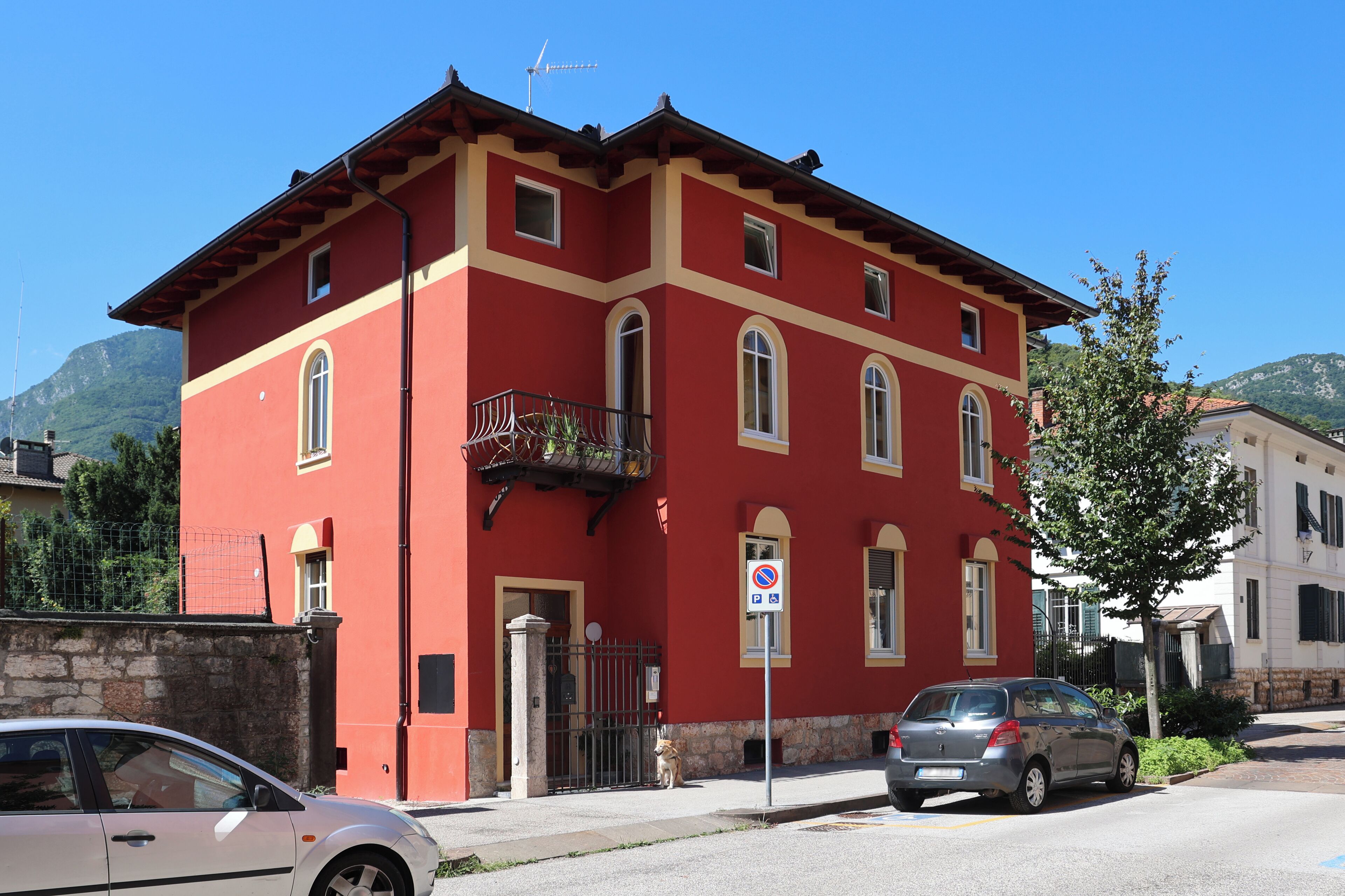 Um edifício vermelho com várias janelas e uma varanda.