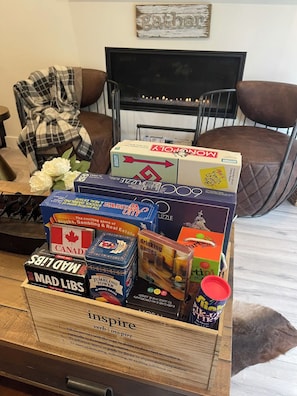 A wooden box filled with board games on a wooden floor.