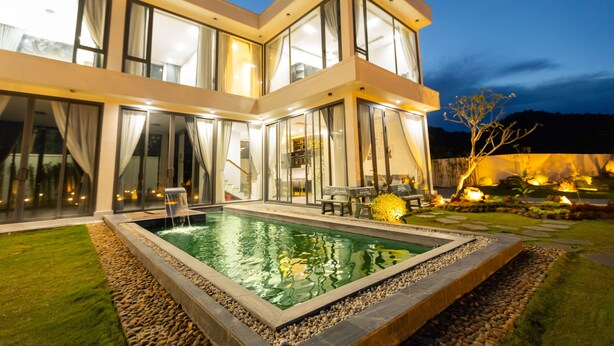 A modern two-story house with a swimming pool, large windows, and outdoor seating. - TKH Resort (Hoa Son)