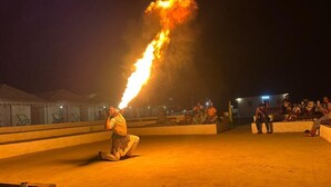 Une personne qui fait une performance avec du feu, en plein air, la nuit.