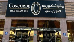 Exterior do Hotel Concorde Bab Al Mutaazam, com uma placa de destaque exibindo o nome do hotel em inglês e árabe.