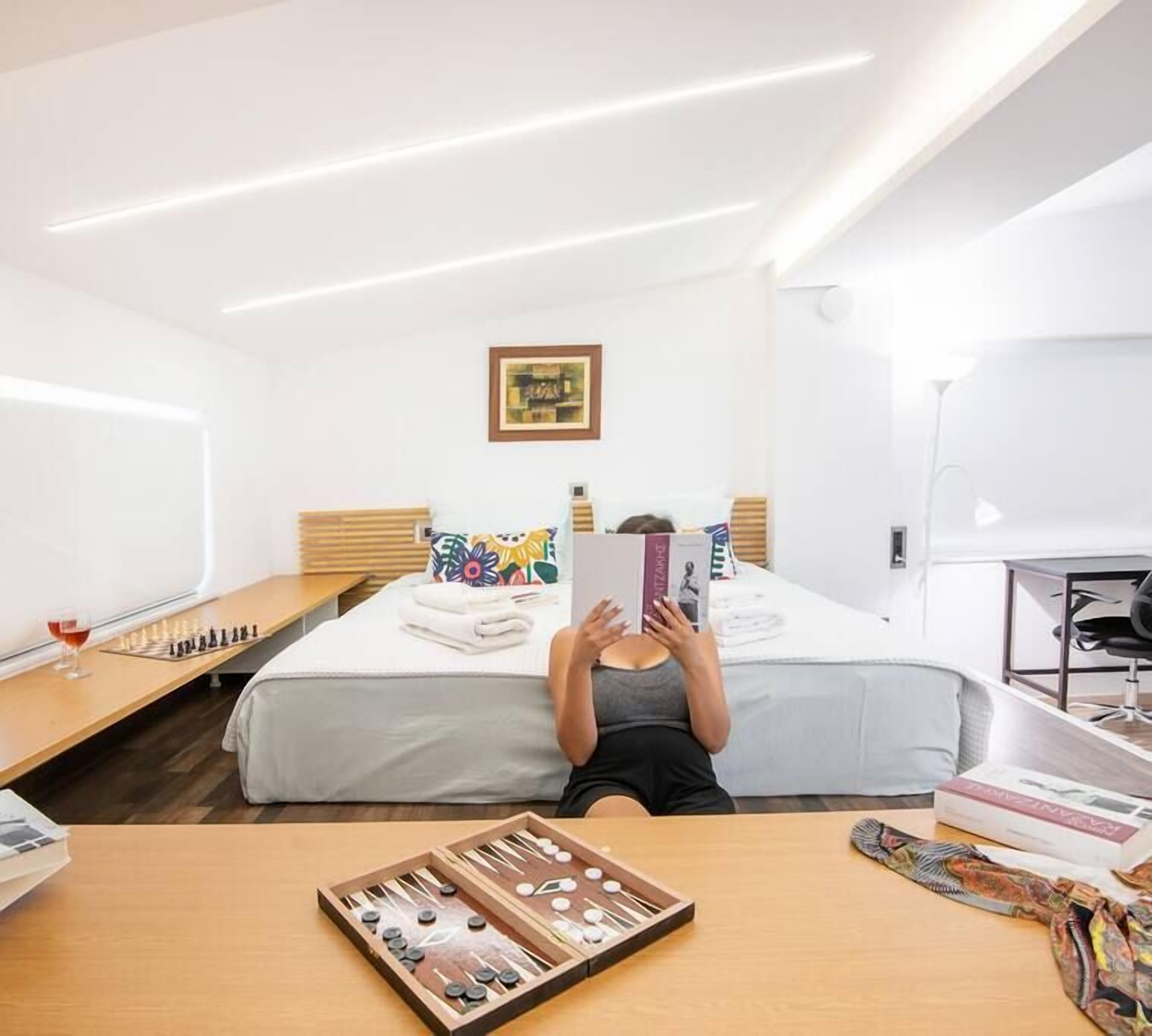 Ein modernes Hotelzimmer mit einem Bett, einem Nachttisch und einem Schreibtisch mit Schachbrett.