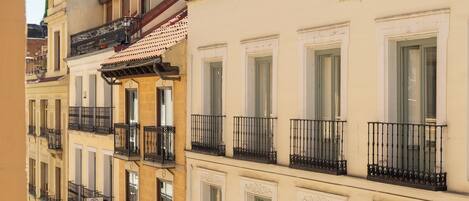 Un immeuble à plusieurs étages doté de balcons, de grandes fenêtres et d’un dôme situé en haut à gauche.
