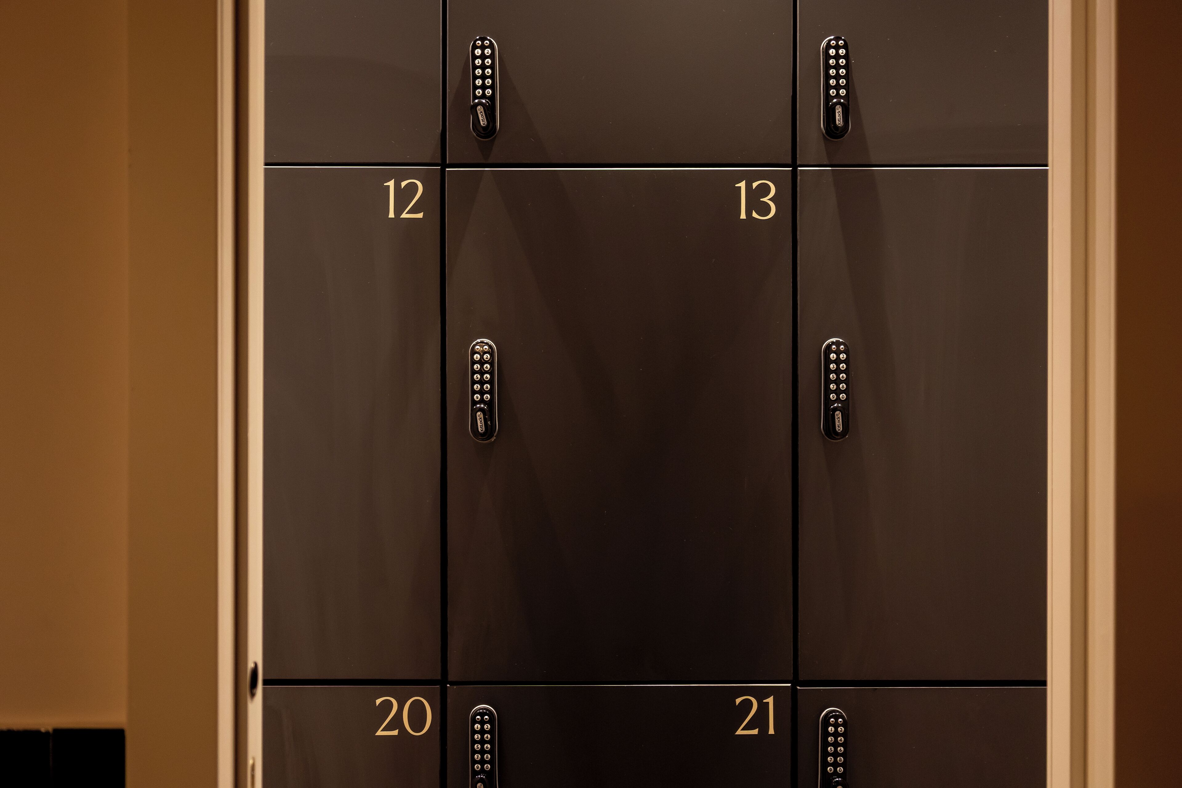 Une série de casiers numérotés de 12 à 21, chacun étant doté d’un trou de serrure et d’un cadenas.