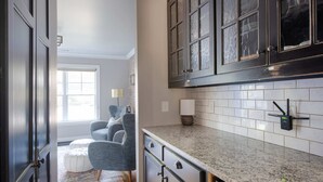 A modern kitchen with dark cabinetry, a granite countertop, and a window providing natural light. - Silver Stallion (Atlanta)