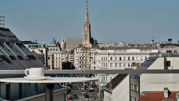 A cityscape with a prominent church spire, modern buildings, and a tram line.