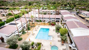 Um resort com piscina central, várias villas e paisagismo exuberante.