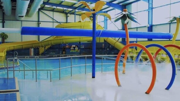 An indoor swimming pool with a water slide and colorful rings. - Meadow View 3-bed Caravan - Sleeps 8 - Petfriendly (Skegness)