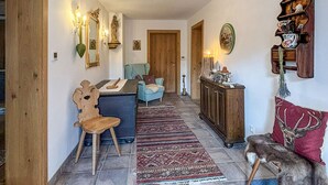 Un salon chaleureux avec un fauteuil bleu, un meuble en bois et un tapis.