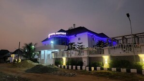 A hotel with a sign reading "BLUE HOTEL APARTMENT" and a modern design with blue lighting accents. - Immaculate Hotel Apartment And Suites  (Asaba)