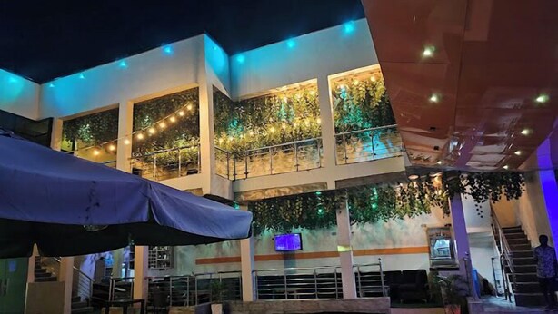 A multi-level building with outdoor seating and a pool area. - Immaculate Hotel Apartment And Suites  (Asaba)