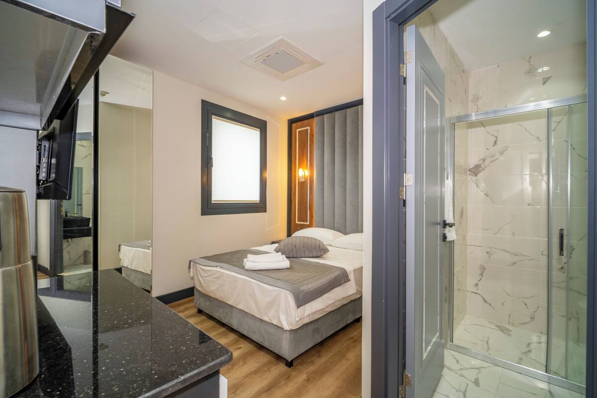 Una habitación de hotel moderna con cama, ducha y baño.