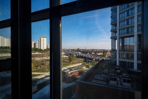 A view from a window overlooking a modern building with multiple floors and large windows. - Rusel Park Residence (Istanbul)