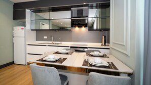 Eine moderne Küche mit Essbereich, ausgestattet mit Kühlschrank, Herd und viel Arbeitsfläche.