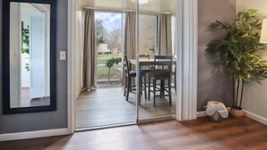 A room with a sliding glass door leading to an outdoor area with a table and chairs.