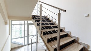 A modern staircase with metal railings and a glass door at the top. - Native Apartments Barska 13 (Kraków)