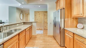 A modern kitchen with wooden cabinets, stainless steel appliances, and a granite countertop. - Condo w/ Balcony > 2 Mi to Angel Fire Resort! (Angel Fire)