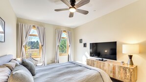 A bedroom with a bed, a television, a ceiling fan, and a window with curtains. - Condo w/ Balcony > 2 Mi to Angel Fire Resort! (Angel Fire)