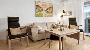 A modern living room with a sofa, two armchairs, a coffee table, and a painting on the wall. - "Answald" - 6km from the sea by Interhome (Aakirkeby)