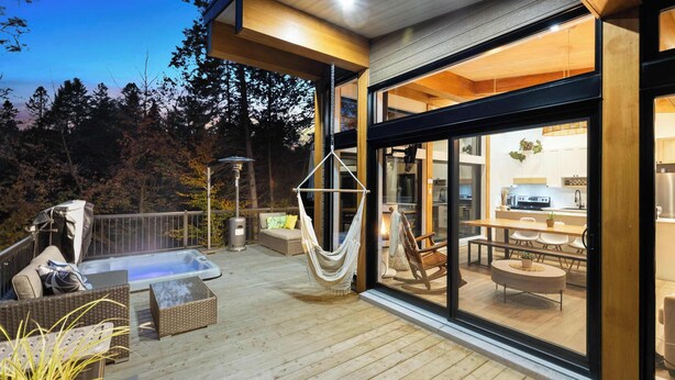Une terrasse dotée de mobilier d’extérieur, d’un jacuzzi et d’un hamac.