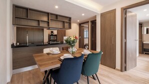 A modern kitchen with wooden cabinets and a dining area with a wooden table and chairs. - Stylish 2BR on Reforma · Near Revolución (Mexico City)