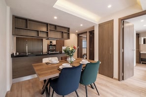 Une cuisine moderne avec des meubles en bois et un coin repas comprenant une table et des chaises en bois.