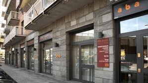 A building with multiple storefronts, including one with a sign reading "aba". - Hotel Aba (Moncalieri)