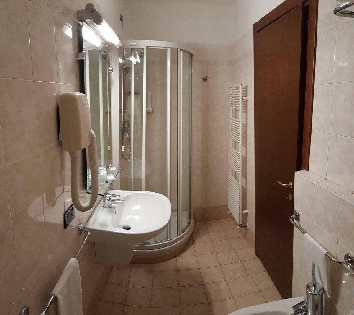 Une salle de bain moderne avec une douche à parois de verre, un lavabo et un porte-serviettes.