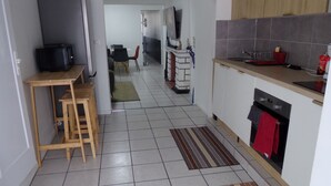 A kitchen with a dining area, a TV, and a refrigerator.