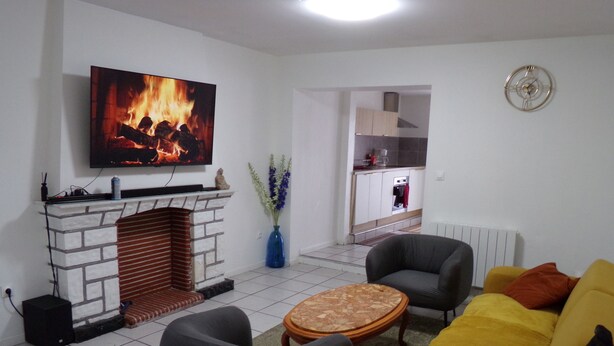 A living room with a fireplace, a television mounted above it, a sofa, and a coffee table.