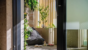 A modern interior with a black sofa, an open book, a glass jar, and a watermelon on the floor. - Apartments & SPA Posesja Plażowa Grzybowo by POSESJA APARTAMENTY 4a I (Grzybowo)