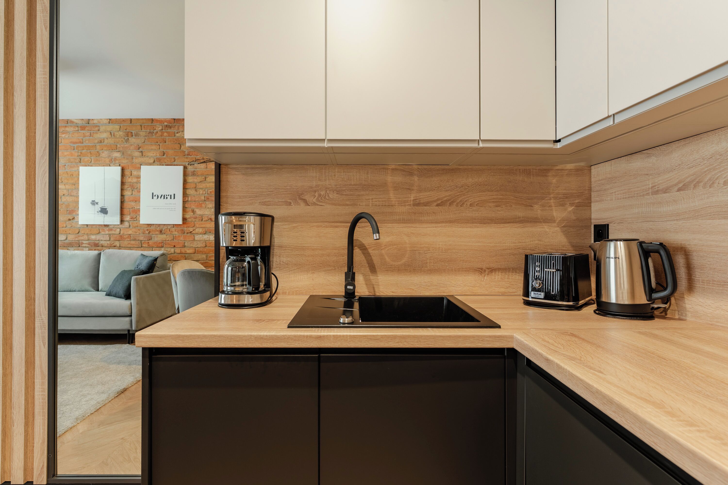 Una cucina moderna con lavello incassato, macchina per il caffè e bollitore.
